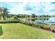 Scenic backyard with green lawn, iron fence, and peaceful water view at 233 Rialto Rd, Kissimmee, FL 34759