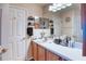 A well-lit bathroom featuring a vanity with dual mirrors, sink, and ample cabinet space at 233 Rialto Rd, Kissimmee, FL 34759
