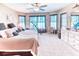 Bright bedroom featuring plush carpet, a ceiling fan, and plenty of natural light from multiple windows at 233 Rialto Rd, Kissimmee, FL 34759