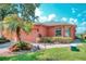 Charming single-story home with well-manicured landscaping, palm tree, and brick walkway at 233 Rialto Rd, Kissimmee, FL 34759
