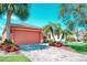 Beautiful home exterior with a large garage door and lush tropical landscaping at 233 Rialto Rd, Kissimmee, FL 34759