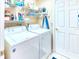 Functional laundry room with washer, dryer, and shelving for storage at 233 Rialto Rd, Kissimmee, FL 34759