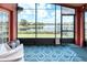 Screened patio with patterned rug and serene lake view through large windows at 233 Rialto Rd, Kissimmee, FL 34759