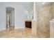Elegant bathroom featuring travertine tile, a double vanity, and glass shower stall at 2333 Pinehurst Ct, Davenport, FL 33837