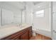 Bathroom with dark wood vanity, a large mirror, and a shower-tub combo at 2333 Pinehurst Ct, Davenport, FL 33837