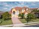 Stunning two-story home with a red tile roof, lush landscaping, and a brick driveway at 2333 Pinehurst Ct, Davenport, FL 33837