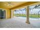 The covered patio features stone floors, columns, and a view of the pool and lush backyard at 2333 Pinehurst Ct, Davenport, FL 33837