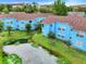 Scenic view of blue condos surrounded by lush greenery and a tranquil pond at 2743 N Poinciana Blvd # 55, Kissimmee, FL 34746
