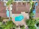 Aerial view of a community pool and spa, surrounded by lush landscaping and blue buildings at 2743 N Poinciana Blvd # 55, Kissimmee, FL 34746