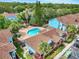 Aerial view showcasing the community pool, spa, and vibrant blue buildings amidst lush greenery at 2743 N Poinciana Blvd # 55, Kissimmee, FL 34746
