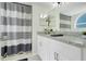 Bright bathroom featuring modern vanity with granite countertop and a shower with a striped curtain at 2743 N Poinciana Blvd # 55, Kissimmee, FL 34746