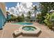 Relaxing community pool and hot tub area with palm trees, lounge chairs, and blue buildings at 2743 N Poinciana Blvd # 55, Kissimmee, FL 34746