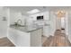 Clean kitchen with white cabinets, a granite countertop bar, stainless steel appliances and a skylight at 2743 N Poinciana Blvd # 55, Kissimmee, FL 34746