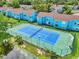 Aerial shot of a blue tennis court surrounded by green landscaping and residential buildings at 2743 N Poinciana Blvd # 55, Kissimmee, FL 34746