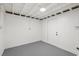 Unfinished basement space, with a door, painted concrete floors and exposed ceiling beams at 304 W 24Th St, Sanford, FL 32771
