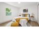 Bright bedroom with white walls, a bed with yellow accents, wood-look flooring, and natural light at 304 W 24Th St, Sanford, FL 32771