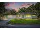 Charming single-story home featuring a lush green lawn, bright green shutters, and a fresh white exterior at 304 W 24Th St, Sanford, FL 32771