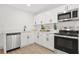 Bright kitchen featuring white cabinets, stainless steel appliances, and light wood floors at 304 W 24Th St, Sanford, FL 32771