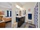 Bright bathroom features a double sink vanity, framed mirrors, and a shower with decorative curtains at 3193 Whispering Trails Ave, Winter Haven, FL 33884
