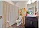 Charming bathroom with a vanity, toilet, decorative shower curtain, and tasteful decor at 3193 Whispering Trails Ave, Winter Haven, FL 33884