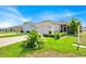 Beautifully landscaped front yard of this one-story home with well-maintained lawns and a concrete driveway at 3193 Whispering Trails Ave, Winter Haven, FL 33884
