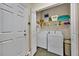 Well-organized laundry room with a washer, dryer, shelving and storage for cleaning supplies at 3193 Whispering Trails Ave, Winter Haven, FL 33884