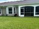 View of the rear exterior with a screen patio and lush, green lawn at 3244 River Branch Cir, Kissimmee, FL 34741