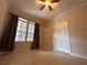 Bedroom with tile flooring, ceiling fan, two large windows, and two closets at 3244 River Branch Cir, Kissimmee, FL 34741