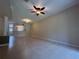 Open concept living space with tile flooring, ceiling fan, and view of kitchen through open partition at 3244 River Branch Cir, Kissimmee, FL 34741