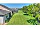 Landscaped backyard with plush lawn and verdant trees extends behind the home at 328 Toldedo Rd, Davenport, FL 33837