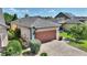 Well-maintained home with a two-car garage, brick-paved driveway, lush landscaping, and architectural details at 328 Toldedo Rd, Davenport, FL 33837
