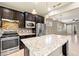 Contemporary kitchen featuring a granite island, stainless steel appliances, and seamlessly opens to the living area at 328 Toldedo Rd, Davenport, FL 33837