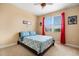 Bedroom features a bed with blue patterned bedding, a window with red curtains and baseball themed ceiling fan at 3759 Eagle Isle Cir, Kissimmee, FL 34746