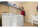 Laundry room features a washer, dryer, sink, and overhead shelving for storage at 3759 Eagle Isle Cir, Kissimmee, FL 34746