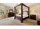 Bedroom with four-poster bed, dresser, and large windows for natural light at 3759 Eagle Isle Cir, Kissimmee, FL 34746
