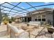 Expansive screened-in patio with a lounge area, dining set, and stylish stone flooring at 3759 Eagle Isle Cir, Kissimmee, FL 34746