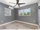 Bedroom with wood-look flooring, ceiling fan, mini-split air conditioning, and two windows at 3824 Hickory Tree Rd, St Cloud, FL 34772