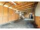 Spacious garage with unfinished plywood walls and exposed wood rafters, providing ample storage at 3824 Hickory Tree Rd, St Cloud, FL 34772