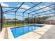Sparkling in-ground pool surrounded by a screened enclosure and a travertine tile deck at 3824 Hickory Tree Rd, St Cloud, FL 34772