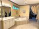 Bright bathroom with a soaking tub and a double vanity, illuminated by modern lighting at 401 Chinahill Ct, Apopka, FL 32712