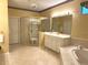 Bright bathroom featuring dual sinks, a shower, a bath and gold-toned fixtures at 401 Chinahill Ct, Apopka, FL 32712