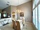 Vaulted ceiling dining area with a view to living room, chandelier, and large windows at 401 Chinahill Ct, Apopka, FL 32712