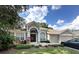 Charming single-story home with a well-manicured lawn, arched entryway, and attached two-car garage at 401 Chinahill Ct, Apopka, FL 32712