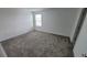 Light-filled bedroom with gray carpet and a large window at 443 Cool Summer Ln, Davenport, FL 33837