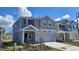 Beautiful new construction home with a well-maintained lawn and a covered front entryway at 443 Cool Summer Ln, Davenport, FL 33837
