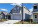 Charming new construction home with a neutral gray exterior and a well-maintained lawn at 443 Cool Summer Ln, Davenport, FL 33837