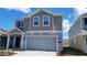 Charming two-story home with a gray color scheme, a well-manicured lawn, and a two-car garage at 443 Cool Summer Ln, Davenport, FL 33837