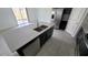 Modern kitchen island with stainless steel sink, faucet, black cabinets, and tile flooring at 443 Cool Summer Ln, Davenport, FL 33837