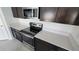 Elegant kitchen with dark wood cabinets, stainless steel appliances, and light-colored countertops at 443 Cool Summer Ln, Davenport, FL 33837