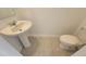 Small powder room with pedestal sink and toilet is a convenient and functional space at 443 Cool Summer Ln, Davenport, FL 33837